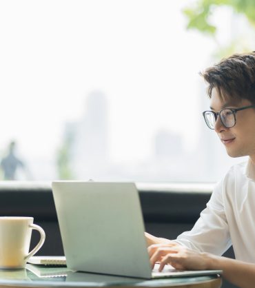 Smart attractive positive asian business male wearing glasses work remote new normal lifestyle hand use laptop tele conference onlive videocall meeting remote business ideas concept