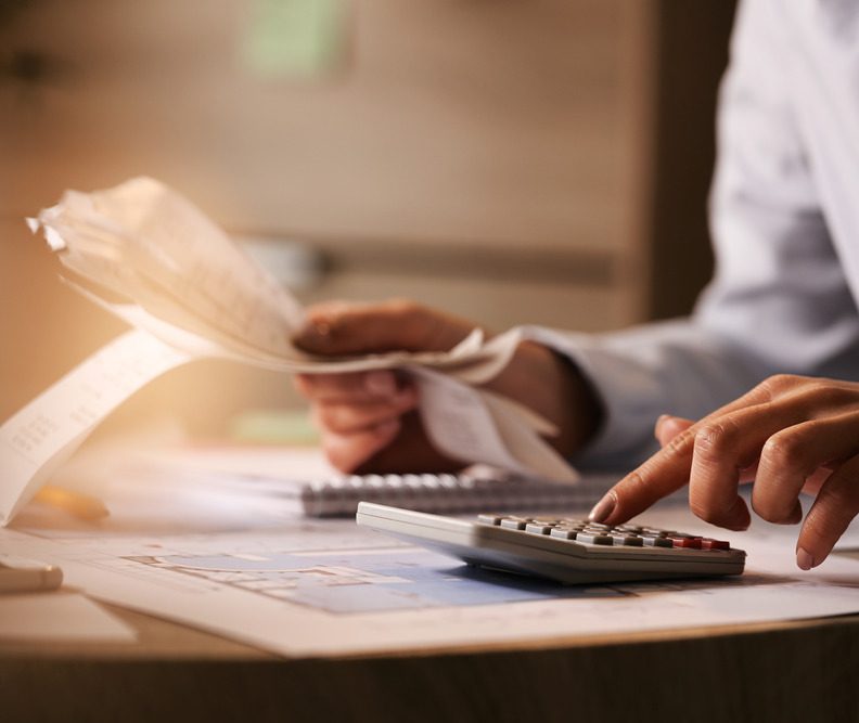 closeup-economist-using-calculator-while-going-through-bills-taxes-office (1)