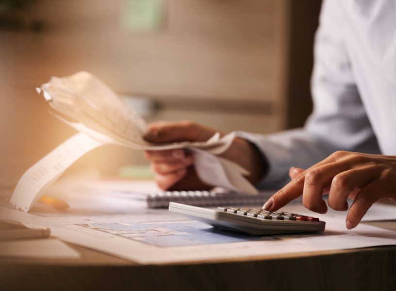 closeup-economist-using-calculator-while-going-through-bills-taxes-office (1)
