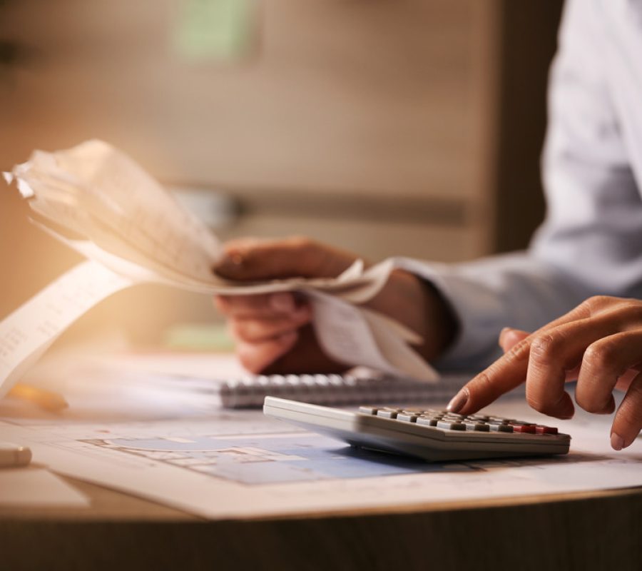 closeup-economist-using-calculator-while-going-through-bills-taxes-office (1)