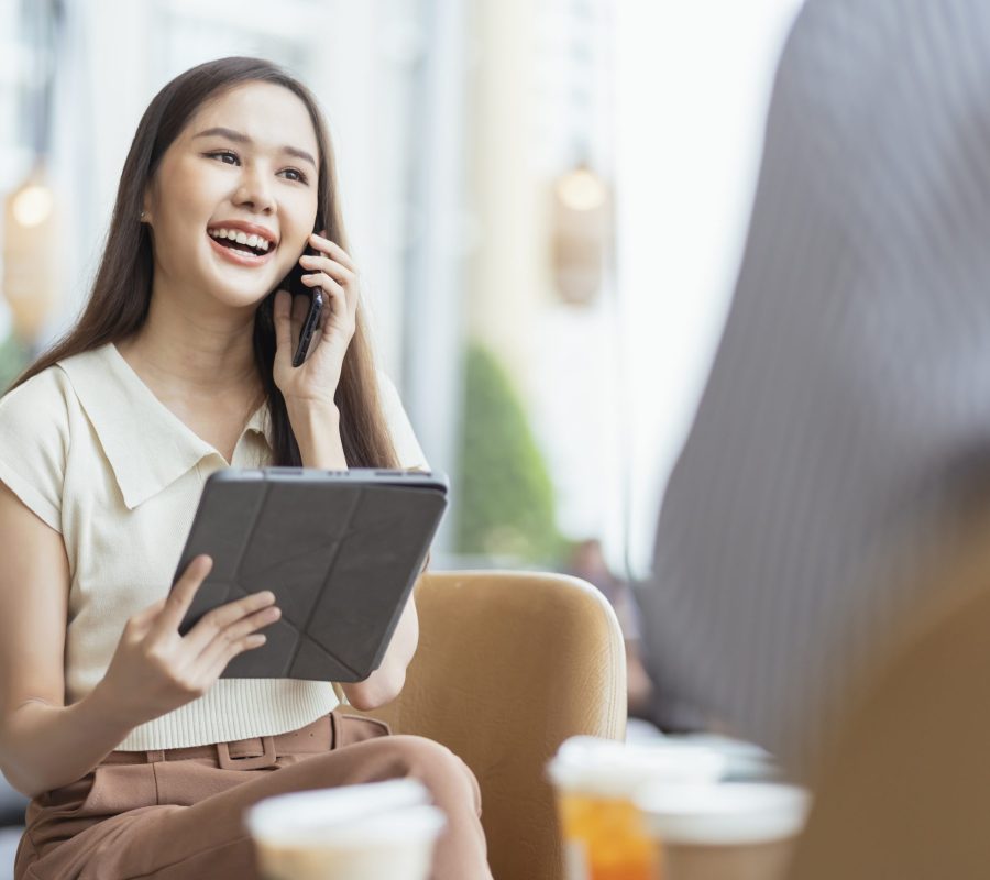 relax leisure attractive smart asian female freelance entrepreneur smile and enjoy working with smartphone and laptop at cafe with blur city business digital nomad remotely work casual ideas concept